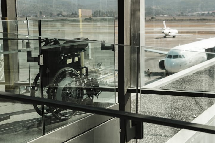 Photo of wheelchair at the airport with a plane in the background