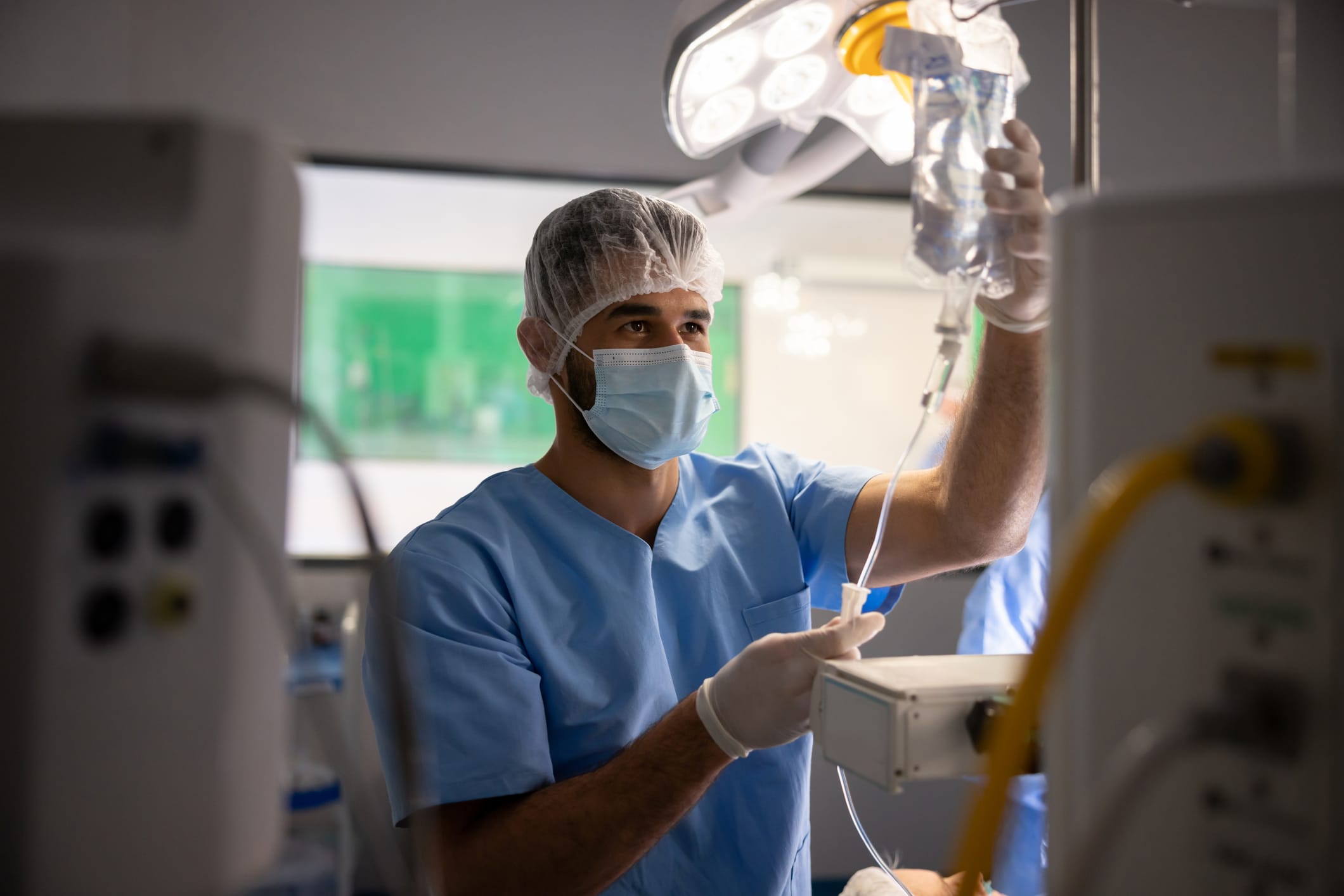 Anesthesiologist preparing an IV drip during surgery