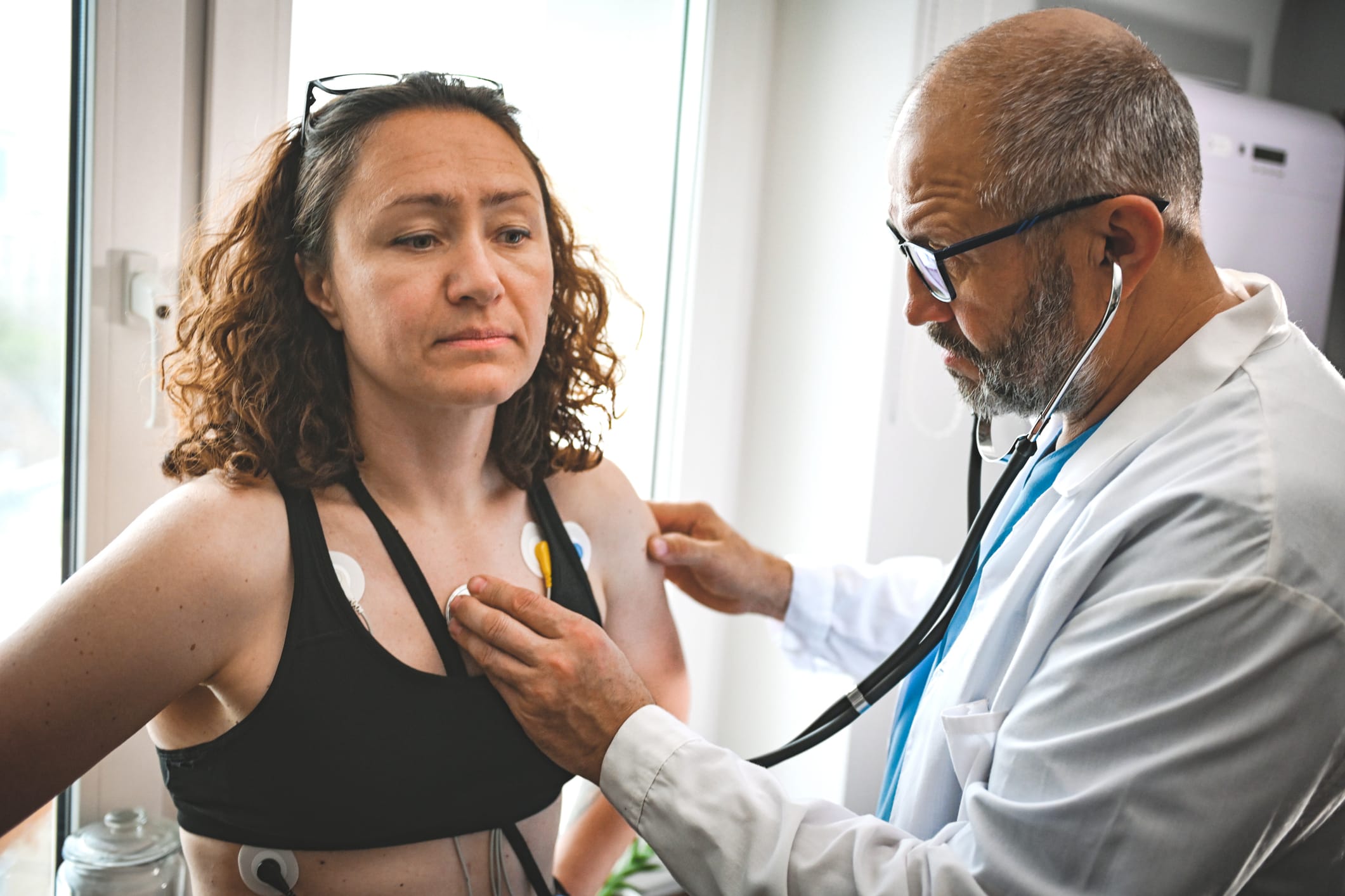 Doctor prepping a woman for electrocardiogram