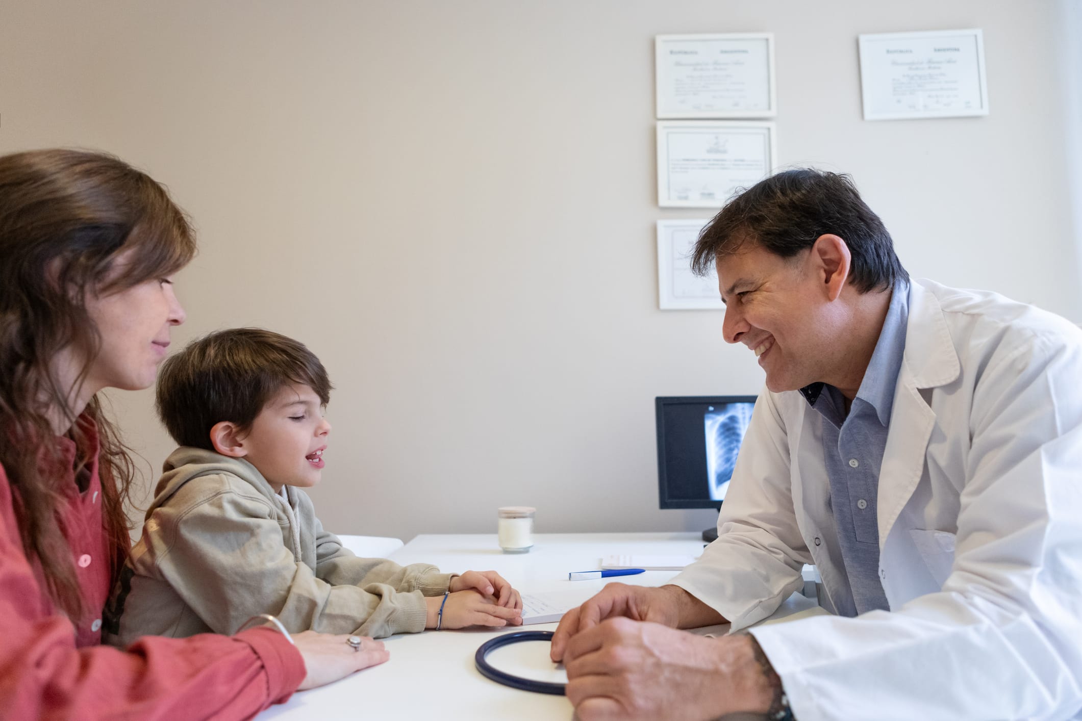 Photo of doctor talking to mother and son