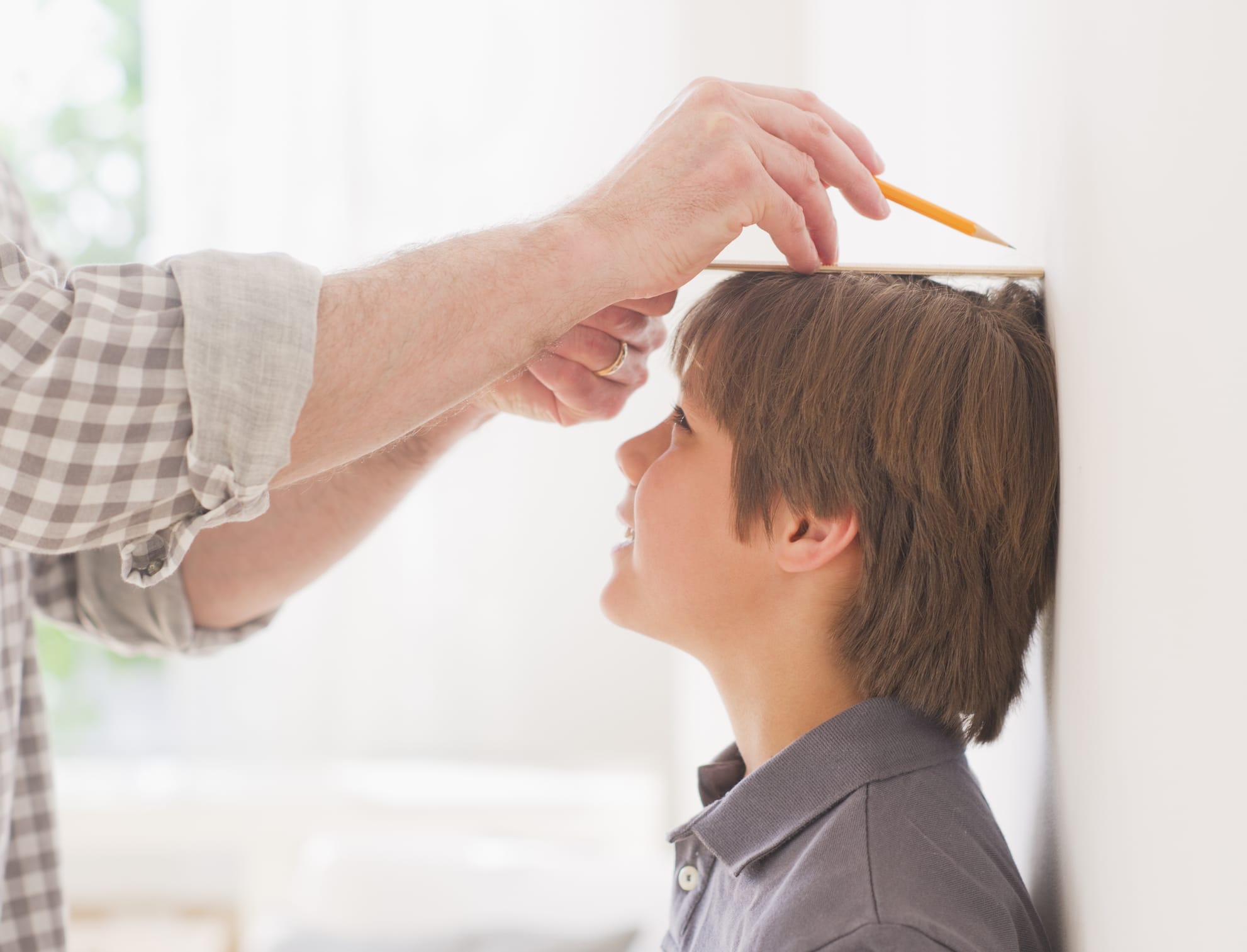 Father measuring boy's height