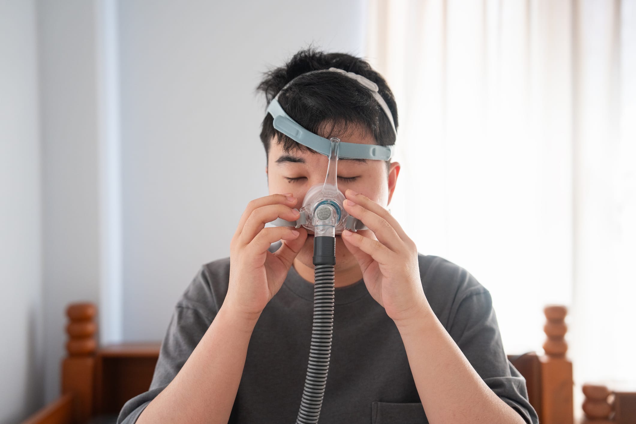 Patient putting on a CPAP headpiece