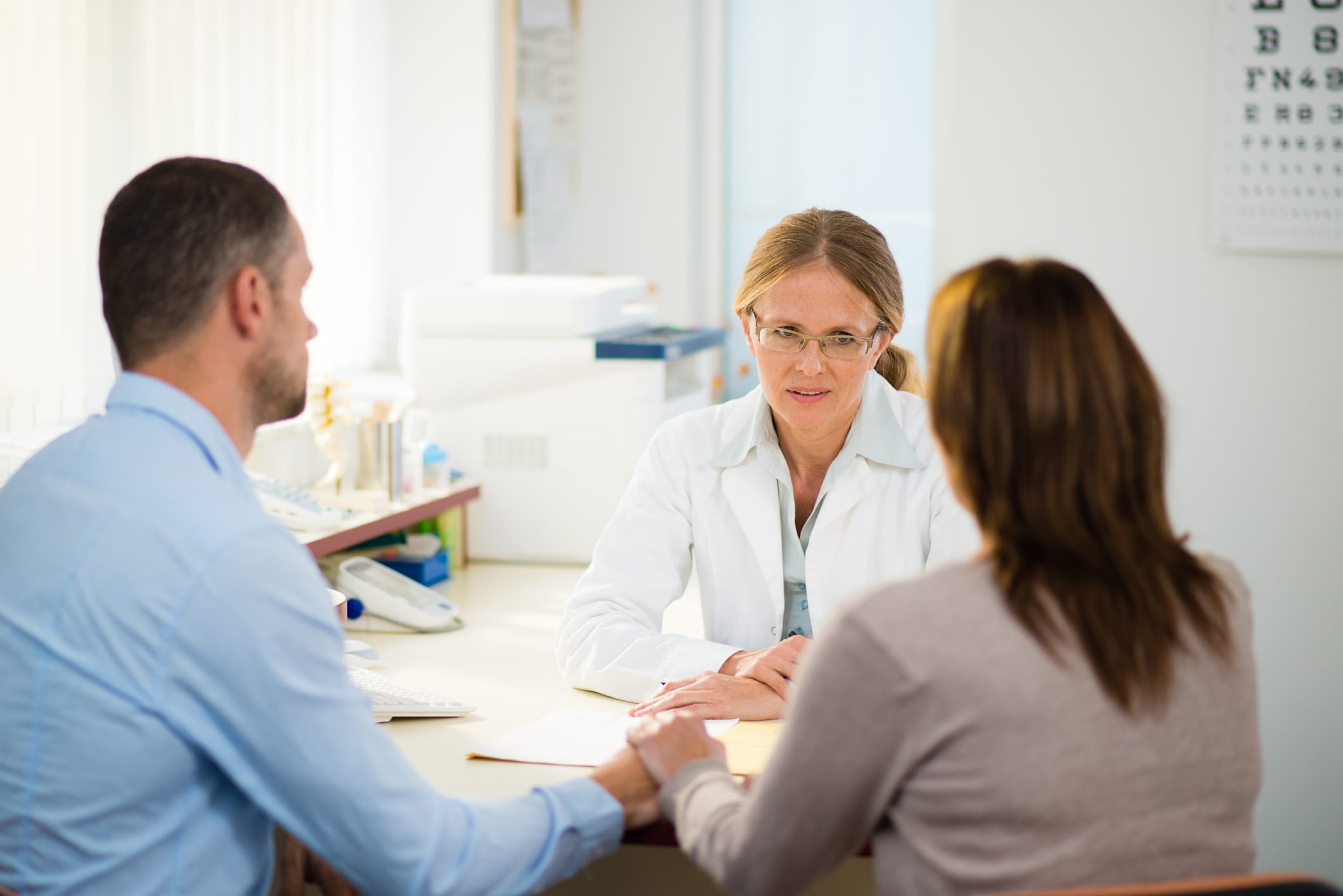 Mid-adult couple having consultation with general practitioner.