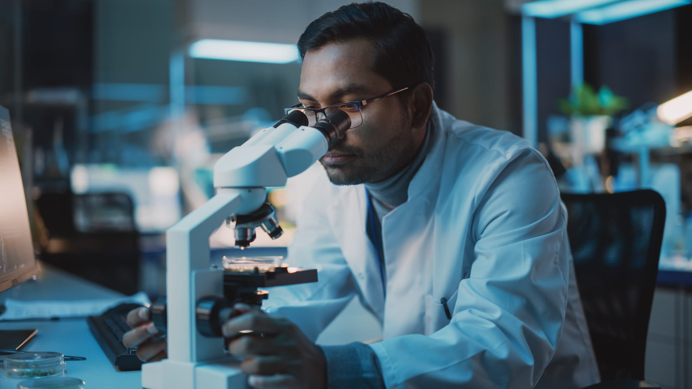 Researcher looking through a microscope