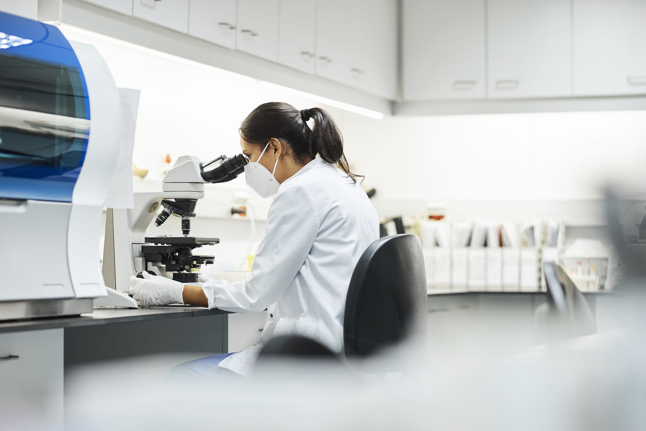 Side view of doctor using microscope in laboratory