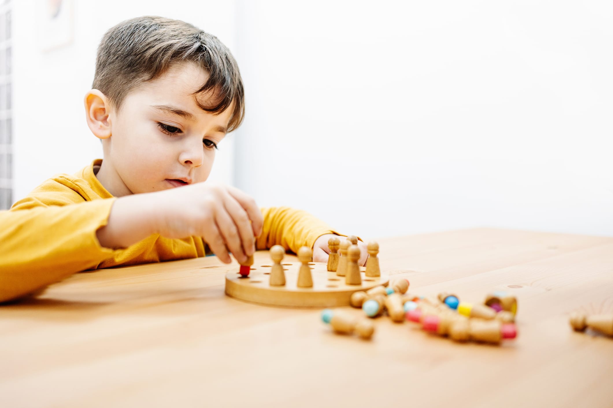 Little boy playing a board game during education therapy