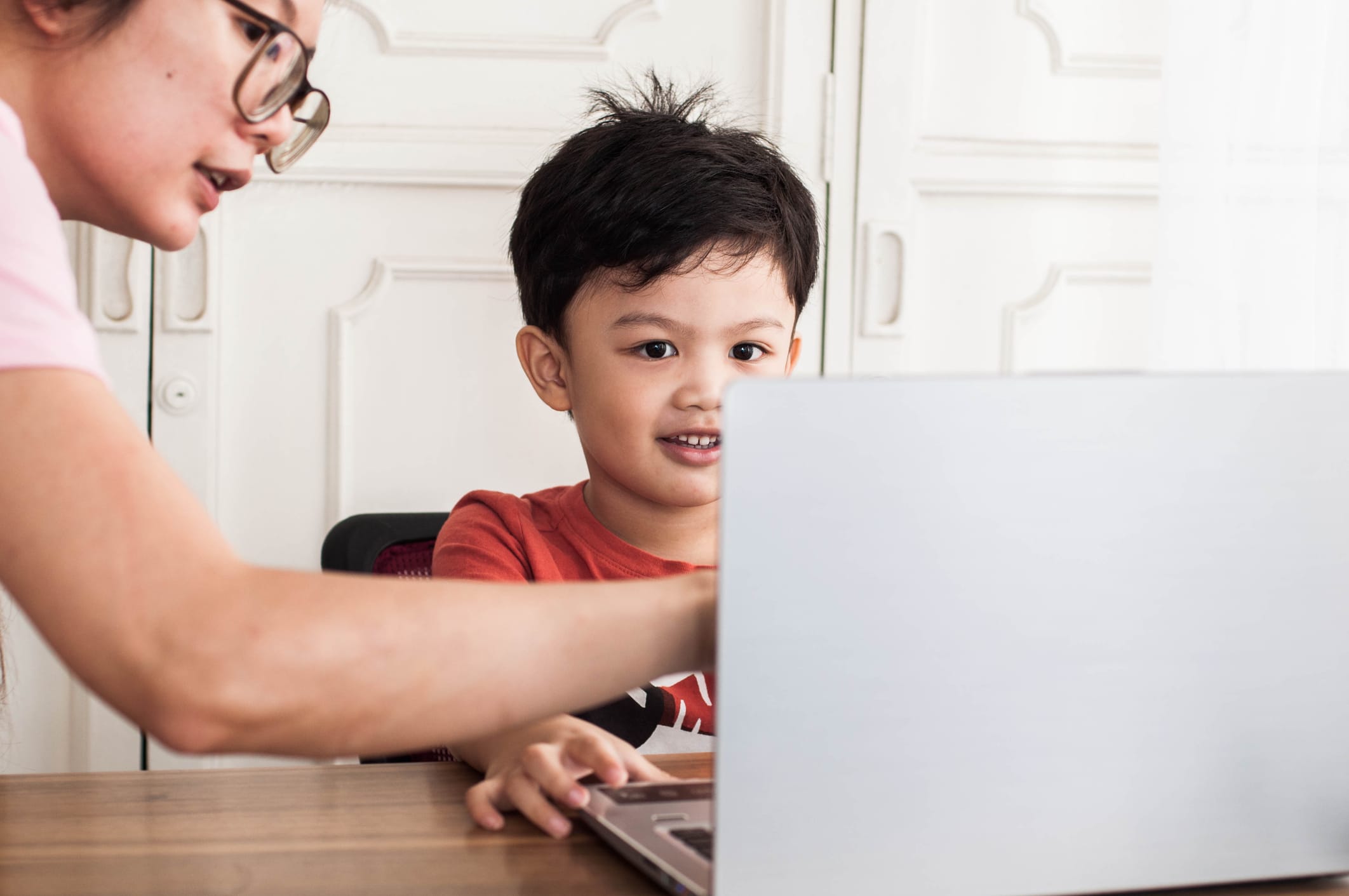 Mother helping son with laptop